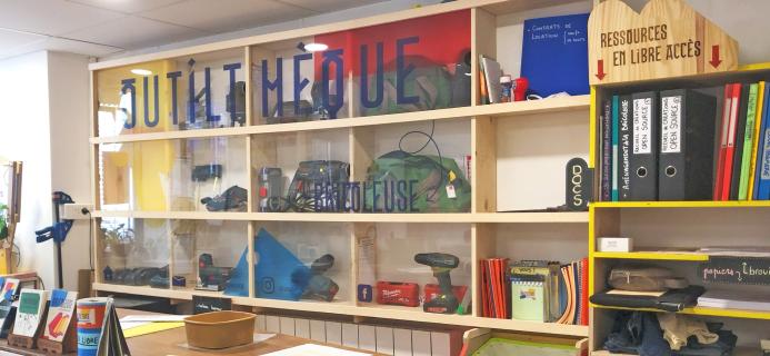 Derrière le comptoir d'accueil, l'Outilthèque t'attends